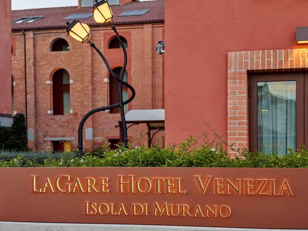 A modern loft-style duplex suite at Hyatt Centric Murano Venice with exposed wooden beams and a view of the Murano canal.