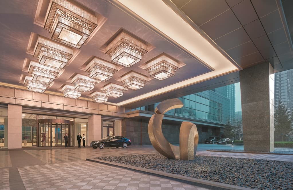Shinsen restaurant at Shangri-La Shenyang featuring a teppanyaki grill and floor-to-ceiling windows overlooking the Shenyang city skyline at night.
