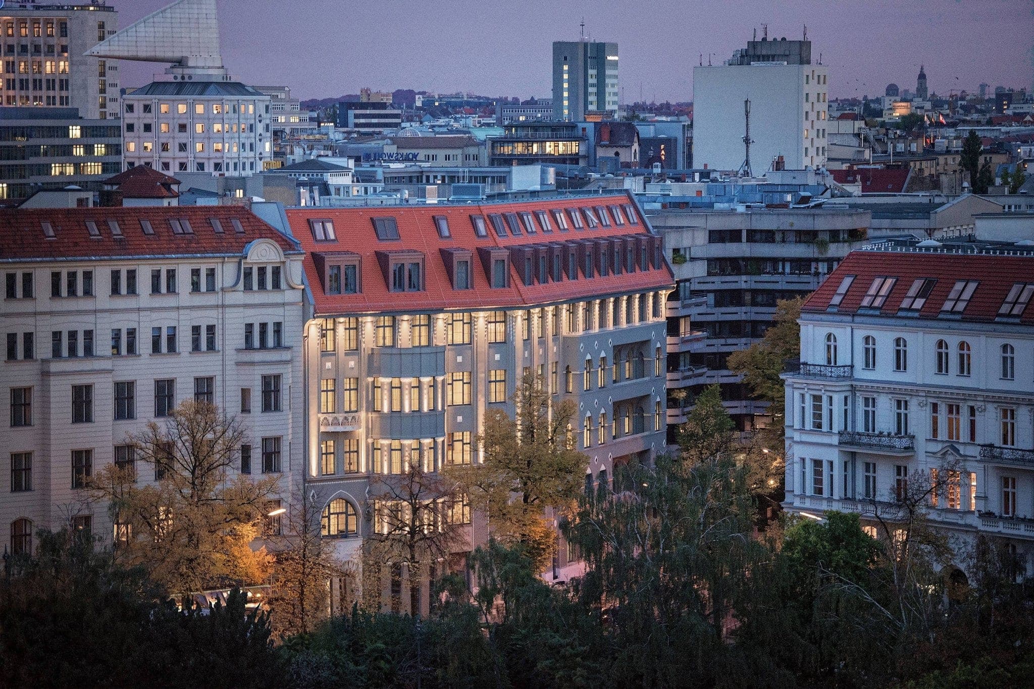 The ornate Art Nouveau entrance canopy of Roomers Berlin Steinplatz glowing warmly at twilight.