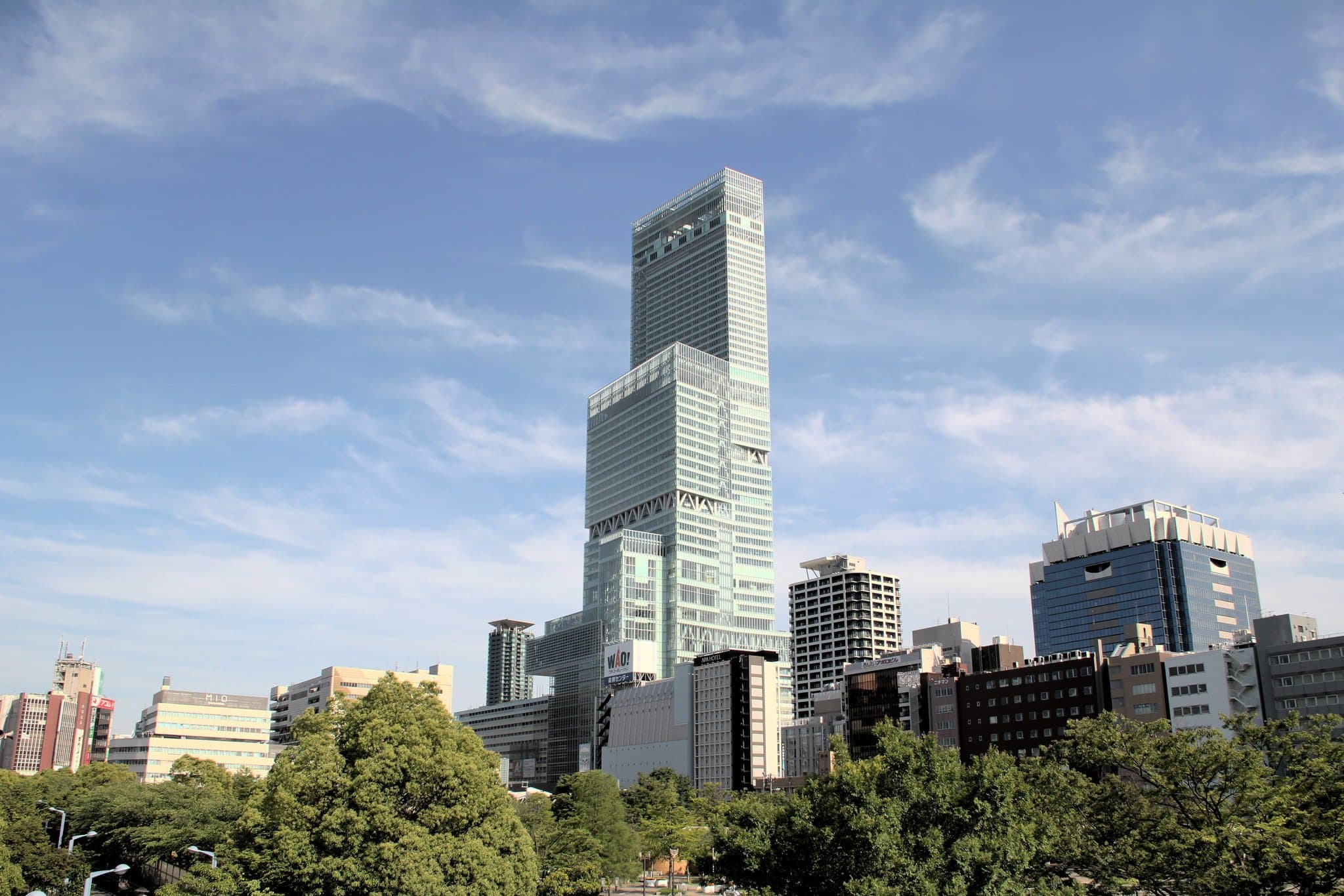 緊鄰落地窗的深浸式浴缸，窗外是大阪阿倍野區璀璨的城市夜景。