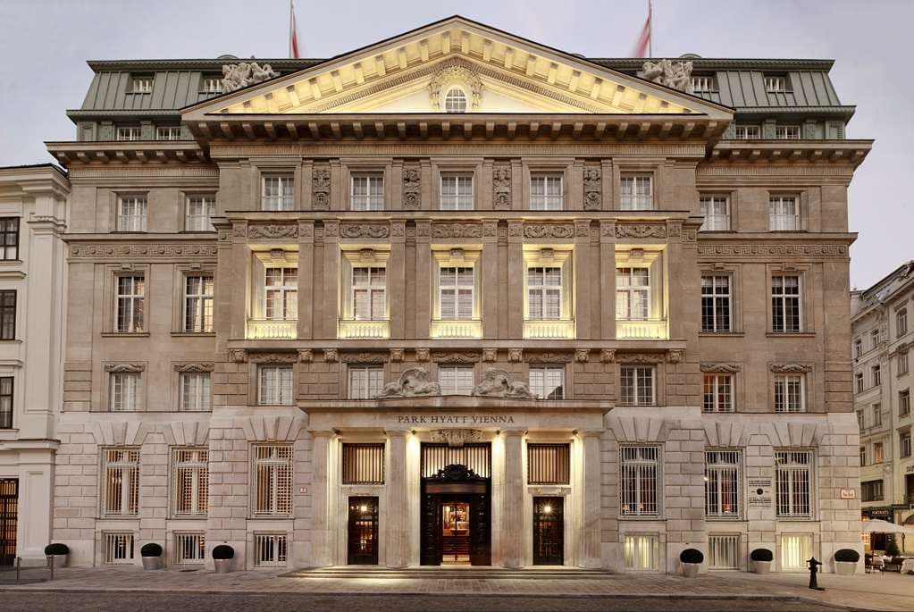 The indoor swimming pool at Park Hyatt Vienna, located inside a former bank vault with gold-bar shaped floor tiles and ambient lighting.