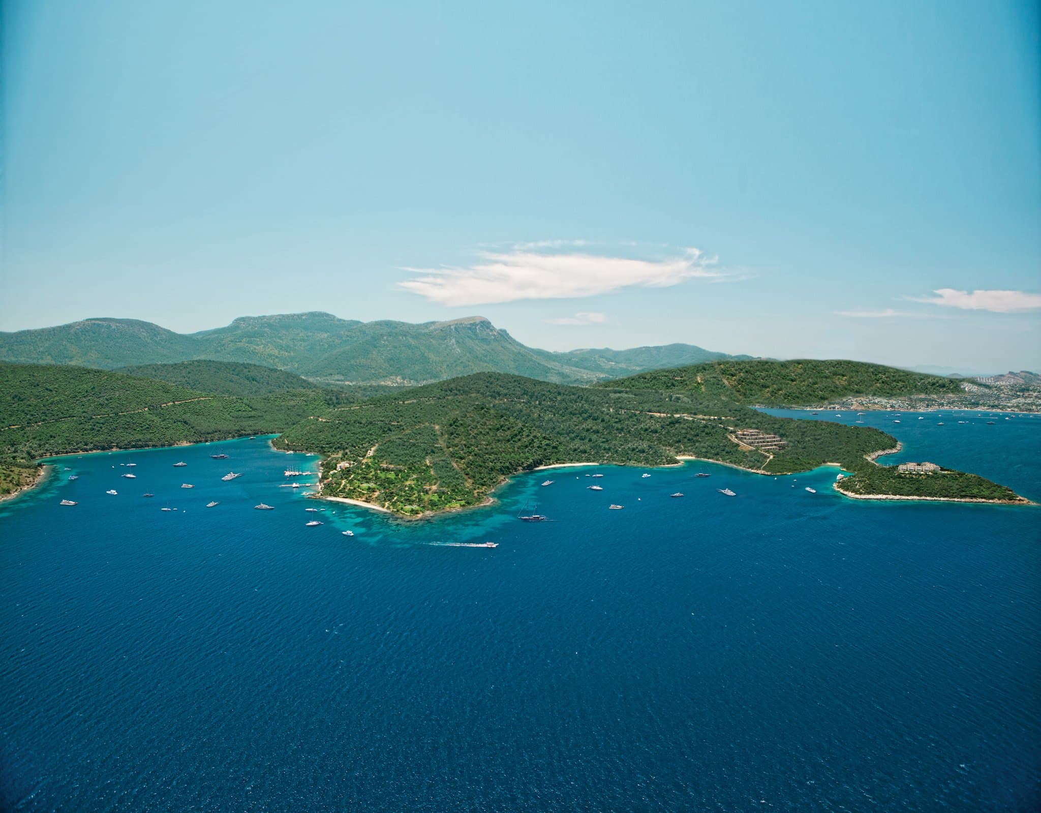 Aerial view of Mandarin Oriental Bodrum's timber decks and turquoise Paradise Bay water.