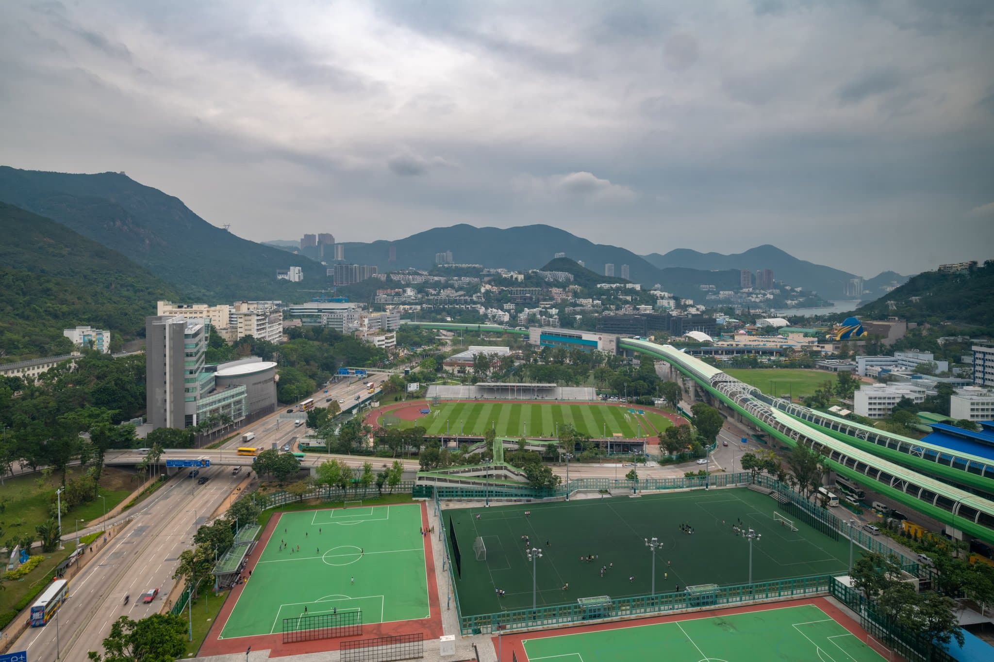 인더스트리얼 시크 가구와 네온 사인, 홍콩의 언덕 전망이 어우러진 해 질 녘의 오볼로 사우스사이드 루프탑 바.
