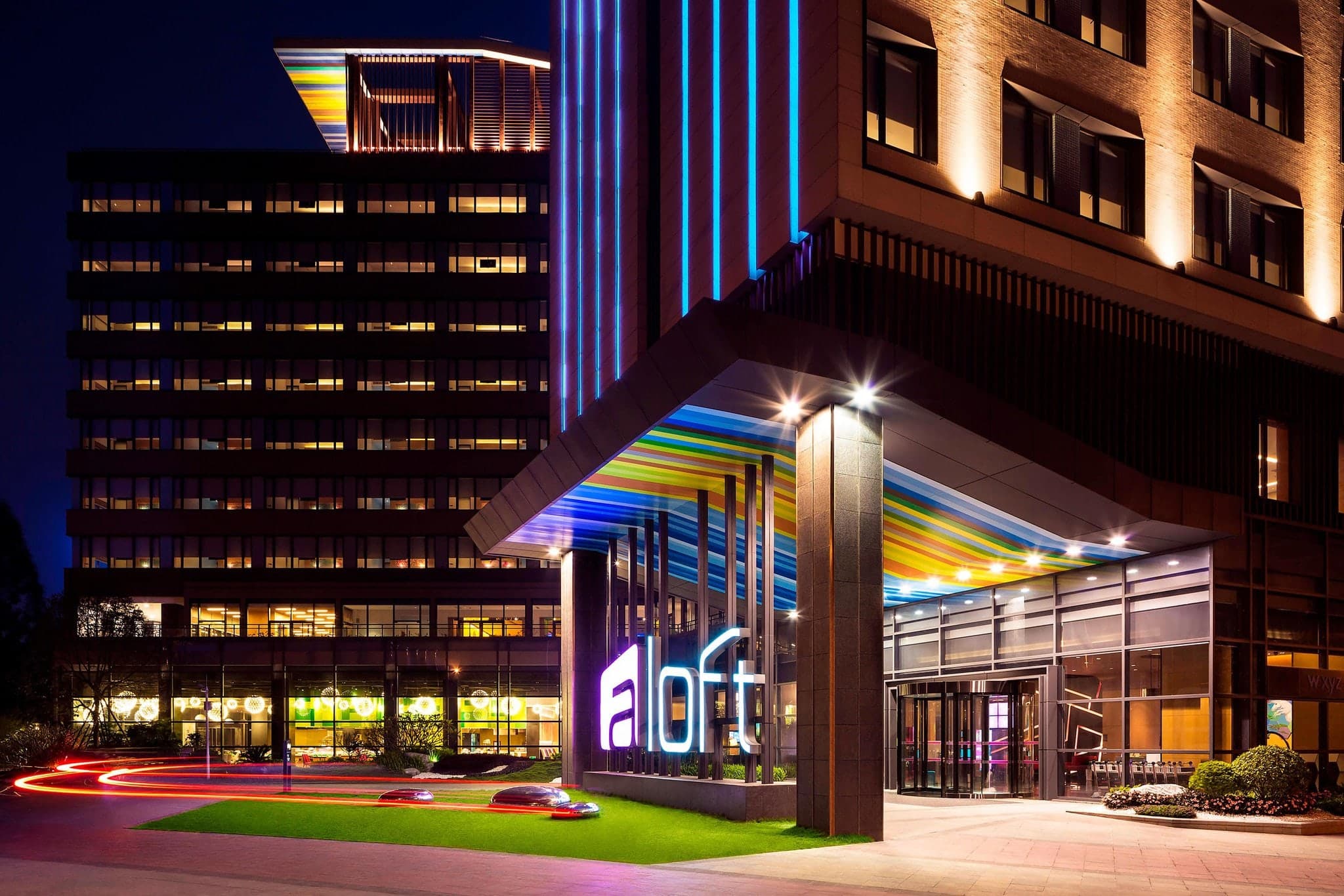 Neon-lit W XYZ Bar at Aloft Guangzhou University Park with modern industrial design elements.