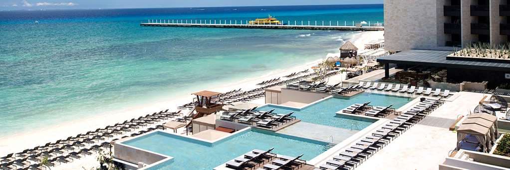 View from the Devossion hotel bridge looking out towards the Caribbean Sea, framing the tiered infinity pools and the Sordo Madaleno architecture.