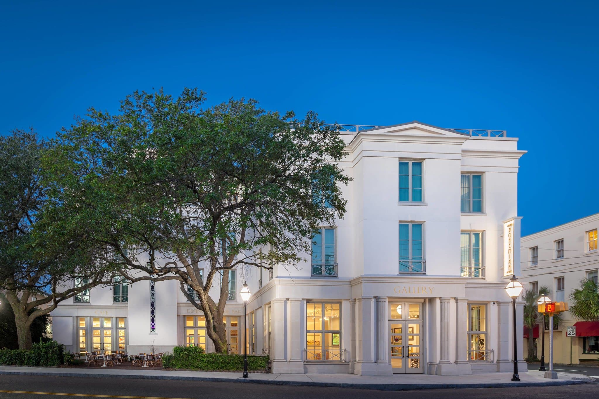 The rooftop terrace at Élevé featuring astroturf, modern white lounge seating, and a view of Charleston's historic church steeples.
