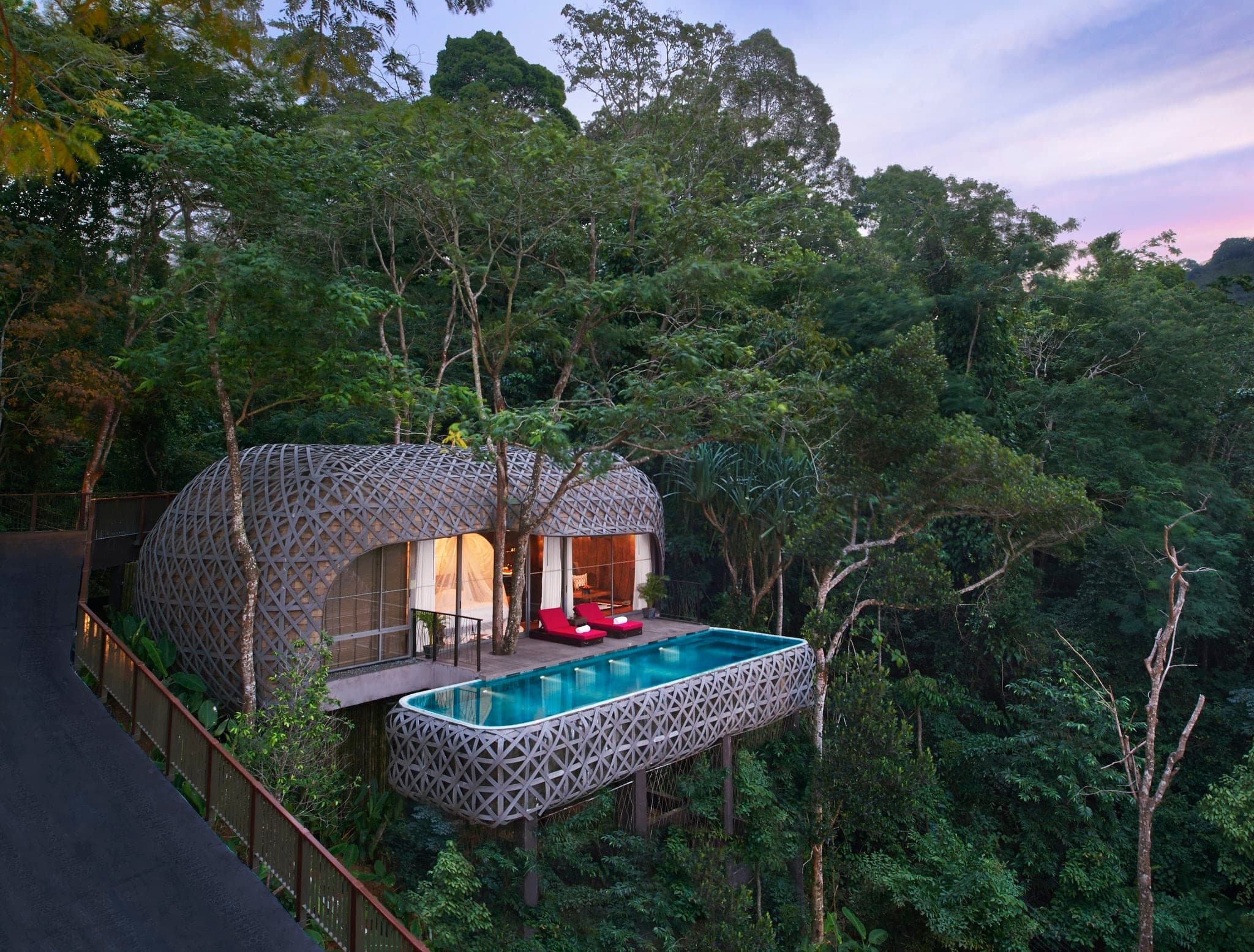 Exterior of Keemala Bird's Nest Pool Villa featuring a woven wood facade suspended over lush rainforest greenery in Phuket.