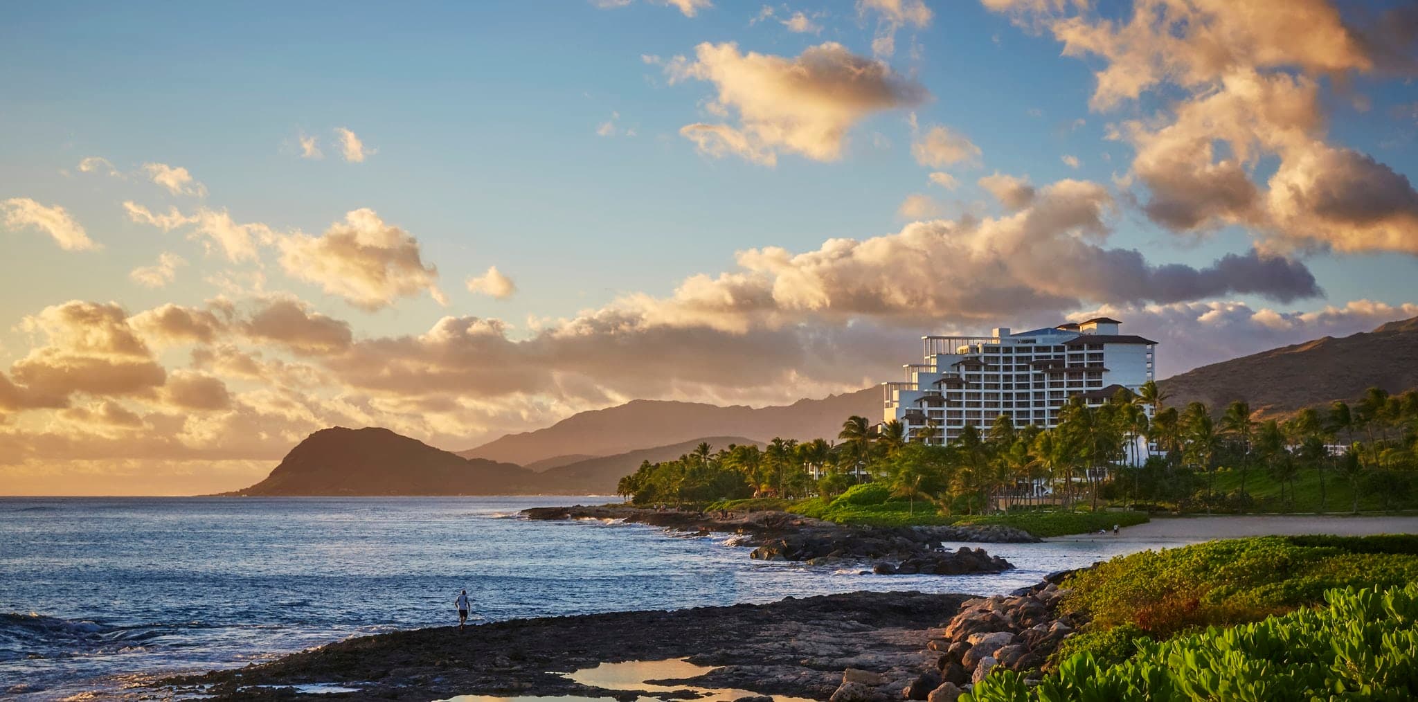 Sunset view of the Adult Infinity Pool at Four Seasons Oahu looking out towards the Pacific Ocean.