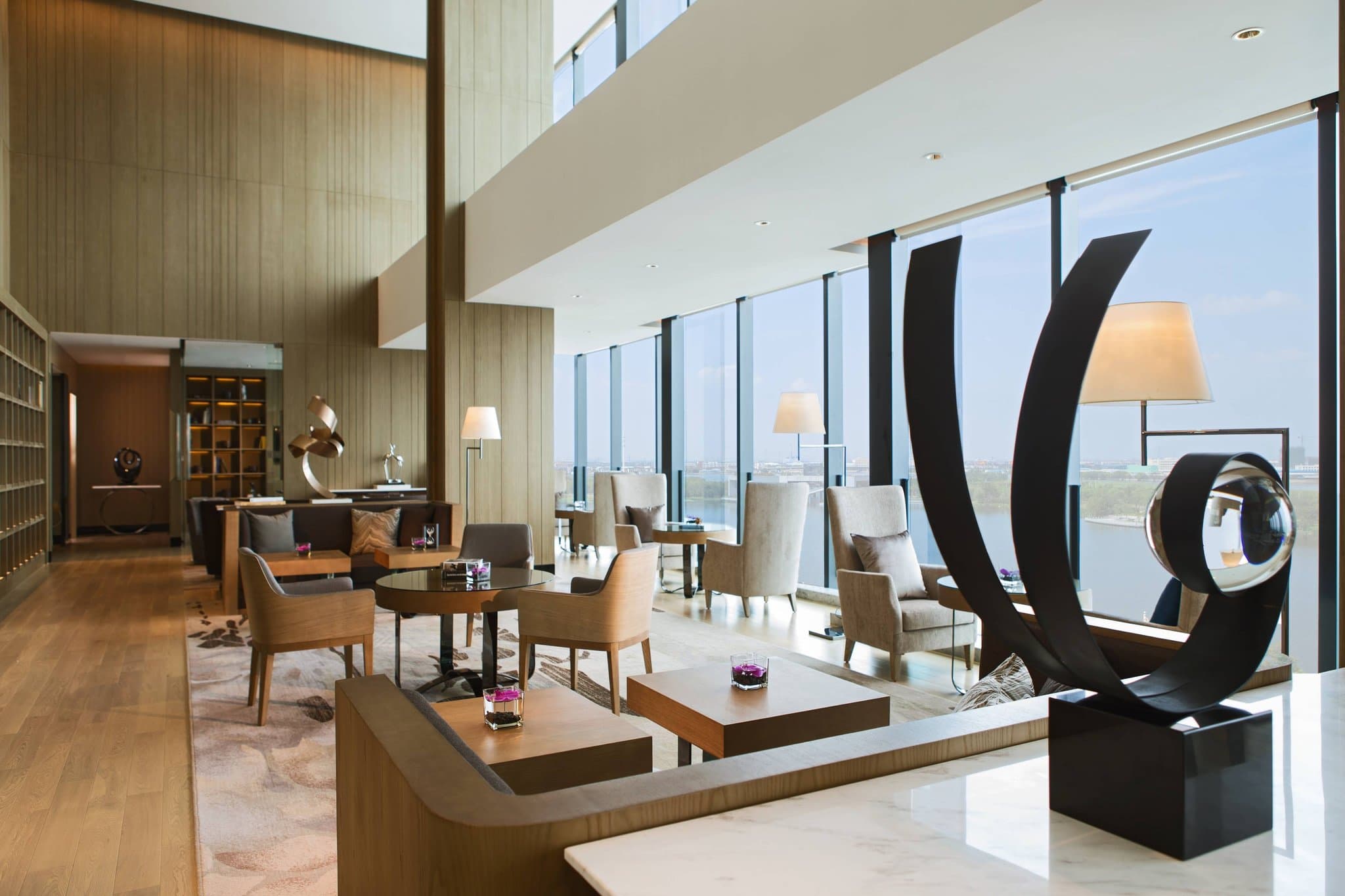 Lobby of Renaissance Suzhou Wujiang featuring large, white sculptural art installations resembling unraveling silkworm cocoons suspended from the ceiling.