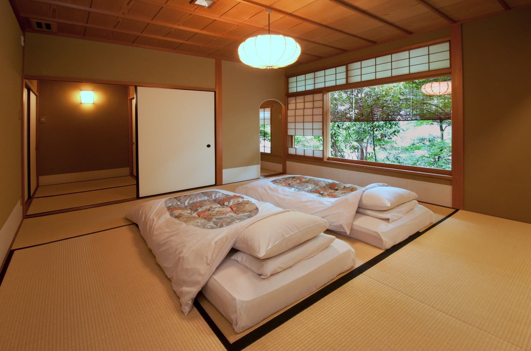 要庵 西富家の伝統的な木造町家の外観、藍色の暖簾と手入れされた松の木。