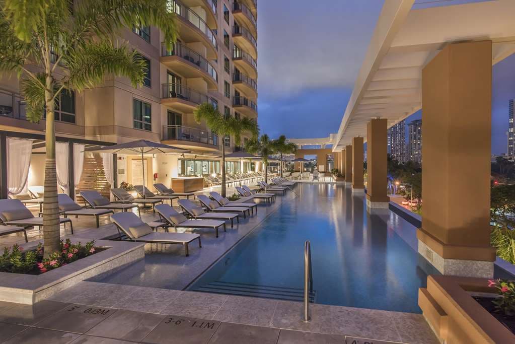 View from The Grand Islander private lanai looking out over the Hilton Hawaiian Village lagoon and Waikiki oceanfront at sunset.