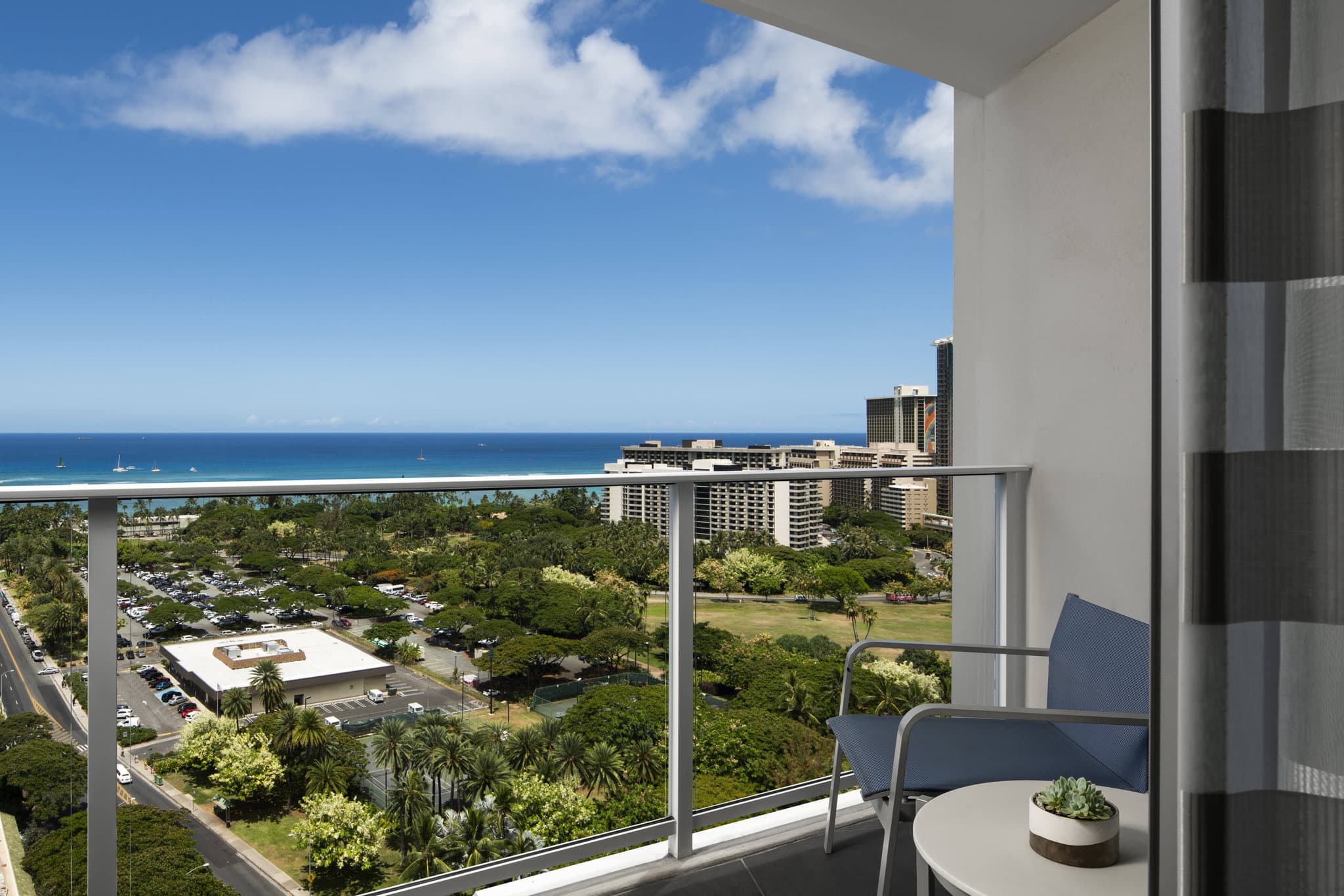 The Ritz-Carlton Residences Waikiki Beach 8th floor infinity pool overlooking the Pacific Ocean skyline at sunset.