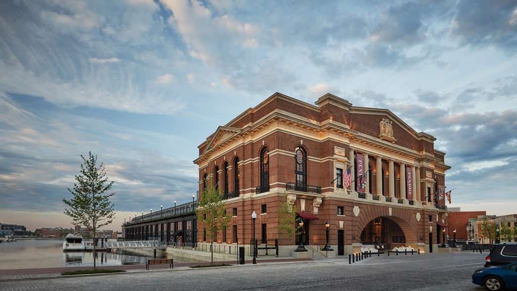 A bronze Fernando Botero horse sculpture stands centrally in the open-air courtyard of the Sagamore Pendry, framed by red brick industrial architecture.