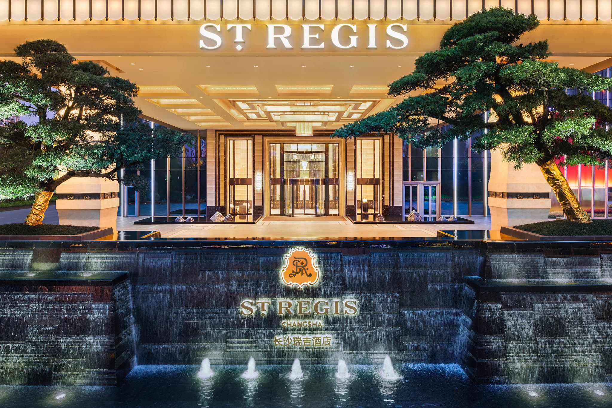 The St. Regis Changsha indoor infinity pool on level 63 overlooking the illuminated city skyline at night.