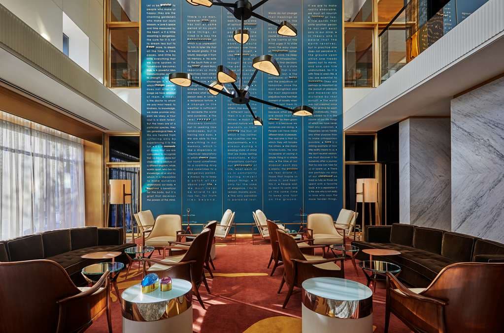The Viceroy Chicago's 18th-floor rooftop terrace at twilight, featuring the illuminated pool and glass facade reflecting the city skyline.