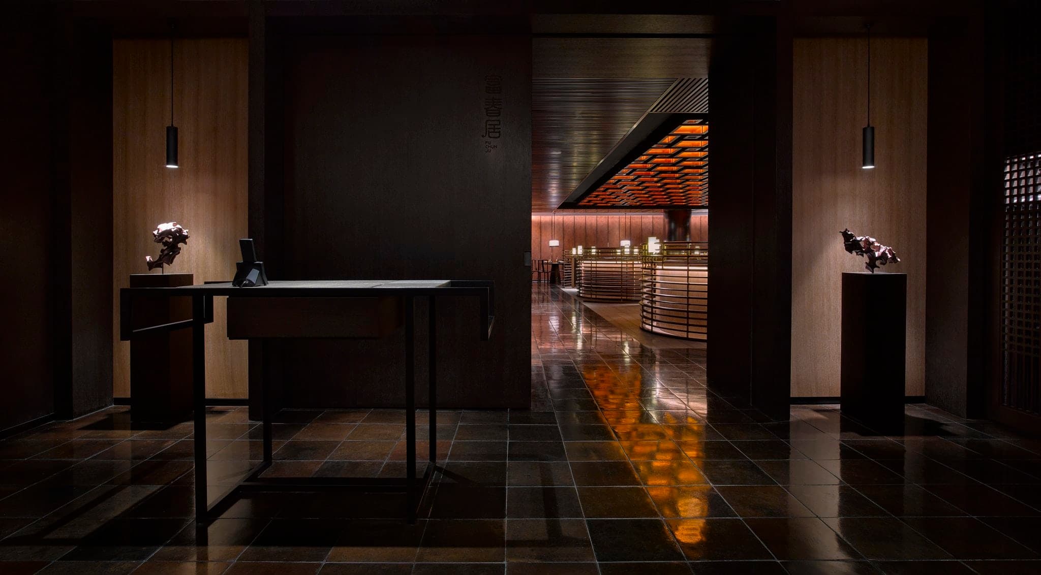 The PuXuan Hotel's glass-brick façade glowing softly at twilight, framing a view of the traditional Beijing hutong rooftops.