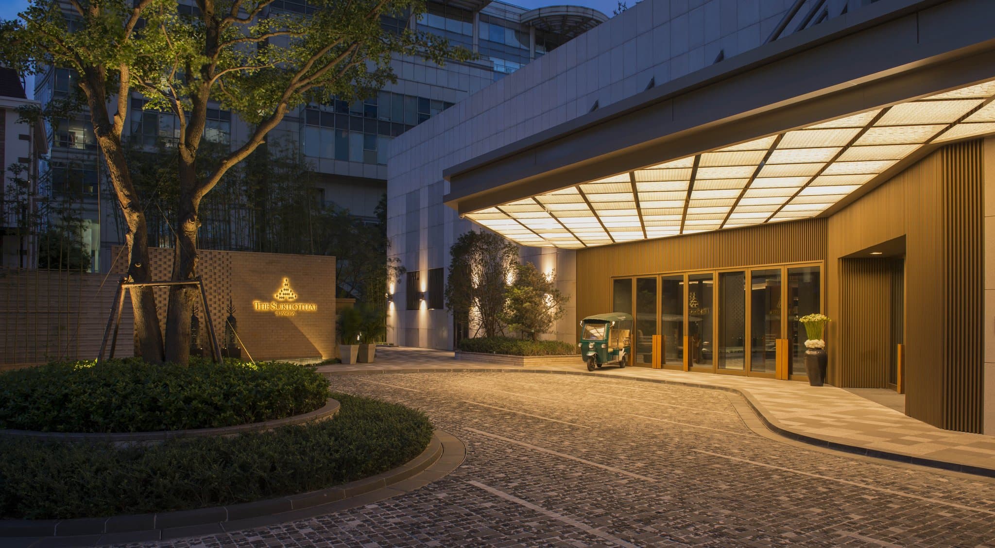 The Sukhothai Shanghai's iconic floating terrazzo staircase illuminated by soft, industrial lighting.