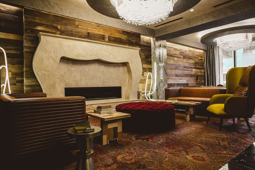 Rooftop lounge at Bobby Hotel Nashville featuring a retrofitted 1956 Greyhound bus bar against the city skyline at dusk.