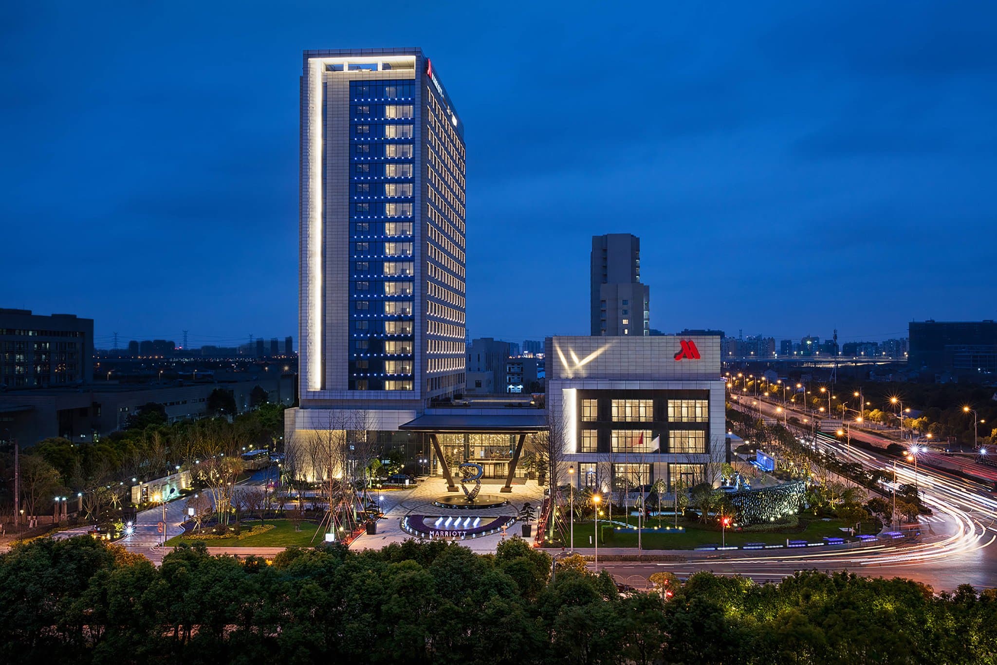Spacious modern guest room at Shanghai Marriott Kangqiao featuring a plush king bed and city views.