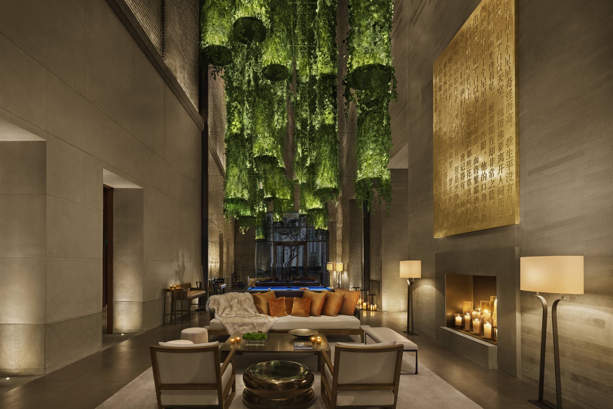 The Shanghai EDITION's 'The Roof' bar featuring an ivy-covered trellis and low lounge seating with a panoramic night view of the illuminated Pudong skyline.