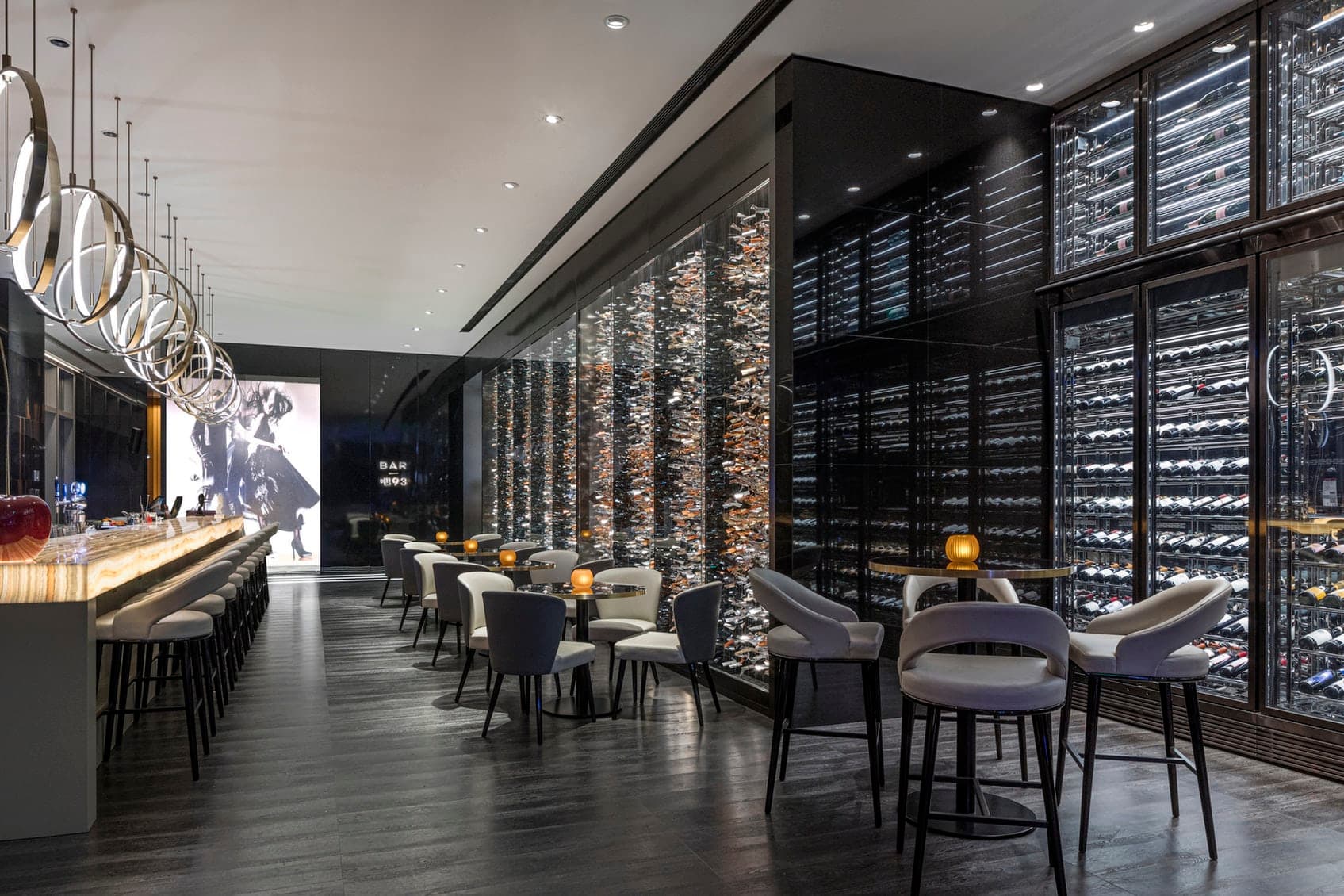 A dramatic view of the Niccolo Changsha Bar 93 with floor-to-ceiling windows overlooking the glowing city skyline at night.
