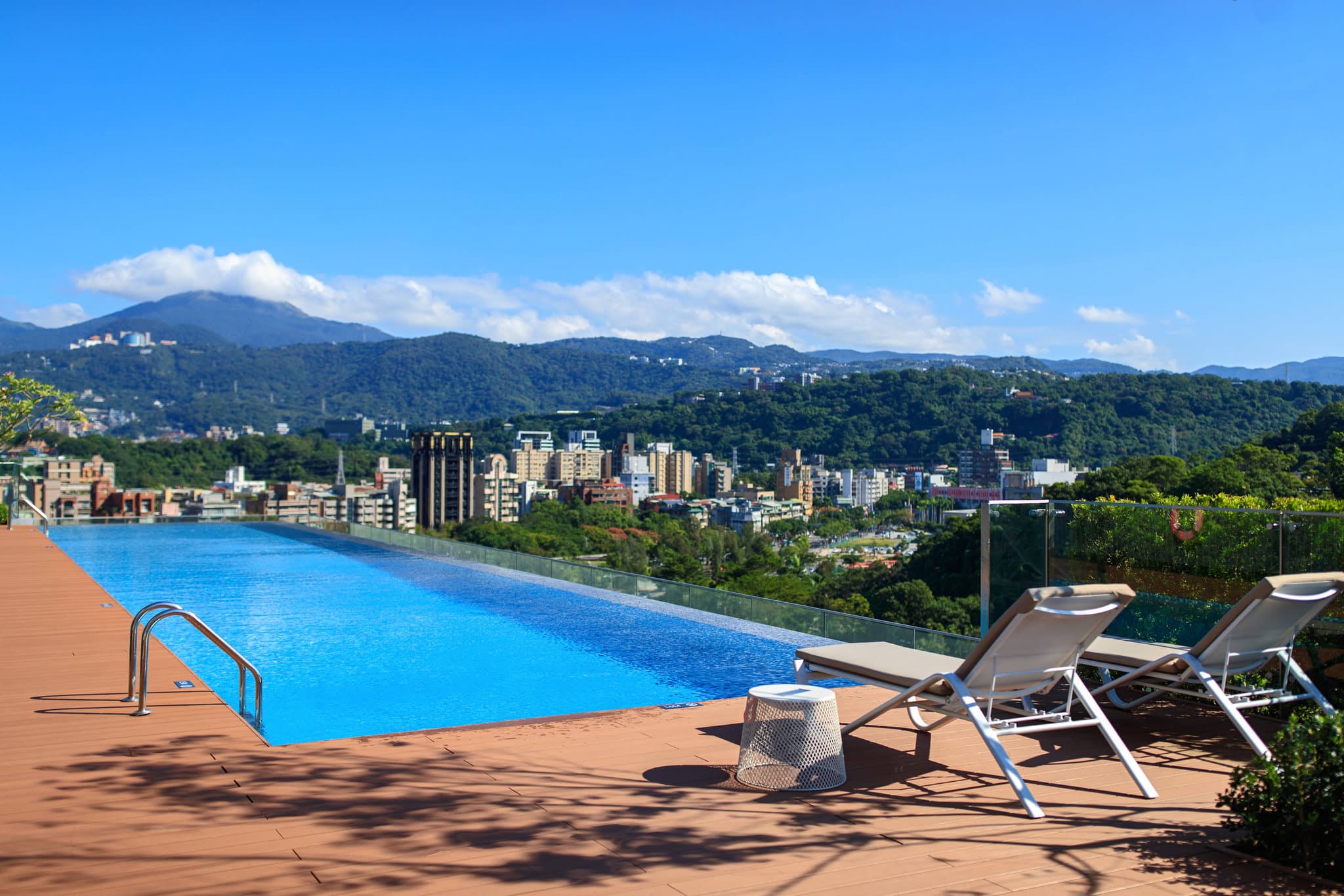 台北士林万丽酒店顶楼无边际泳池，背景为阳明山景。