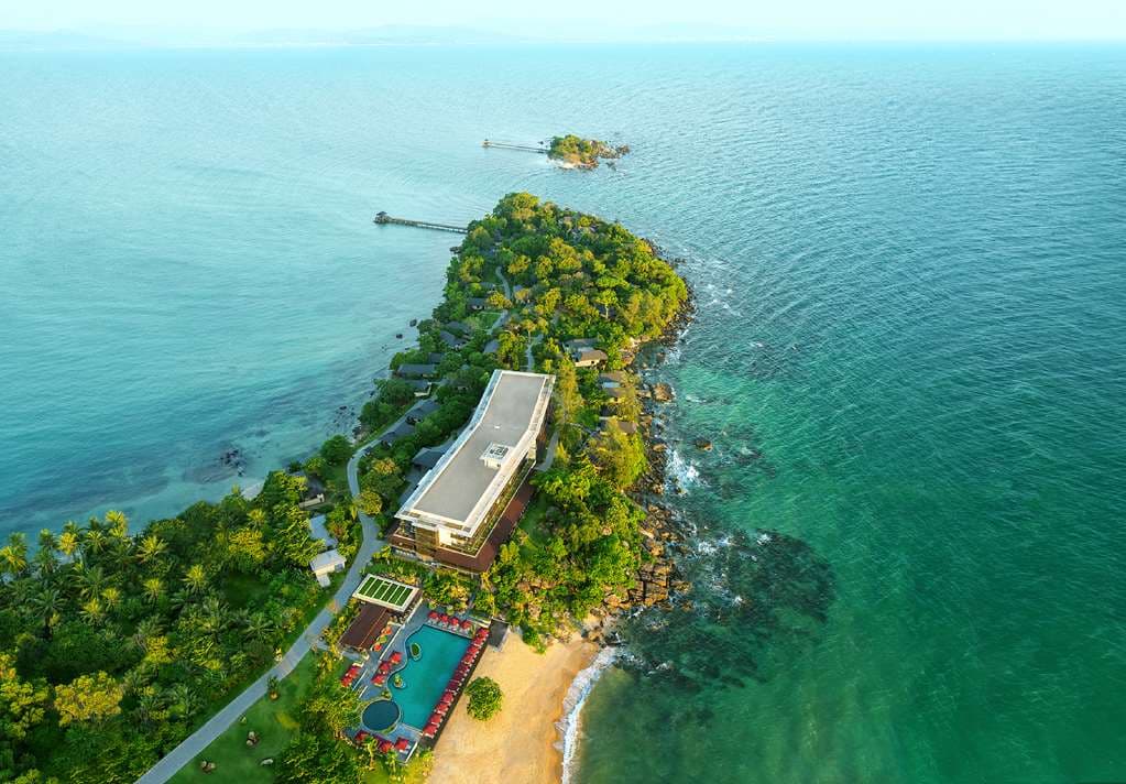 Aerial view of Nam Nghi Coral Peninsula Phu Quoc showing the lush green peninsula surrounded by turquoise waters and the exclusive Rock Island Club.