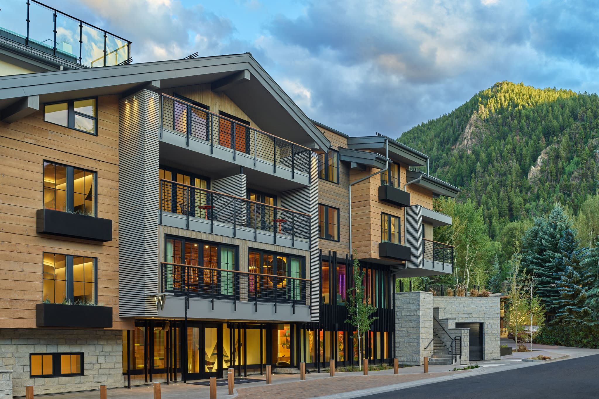 The WET Deck rooftop pool at W Aspen with steam rising from the hot tub against the snowy backdrop of Aspen Mountain.