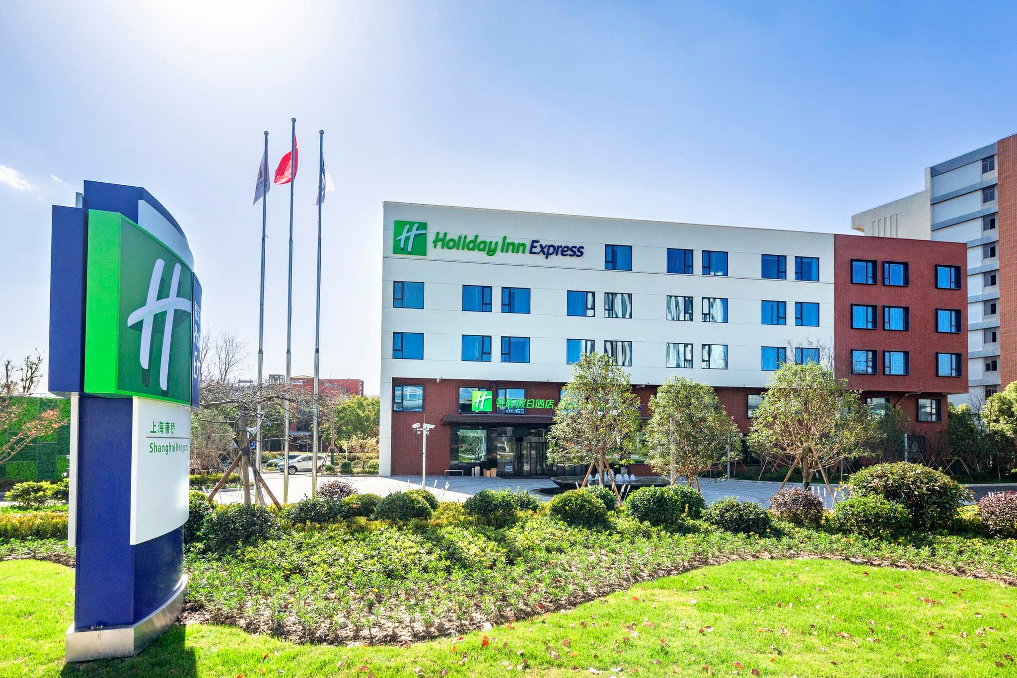 Exterior view of Holiday Inn Exp Kangqiao in Shanghai with modern facade and transit-friendly business hotel setting