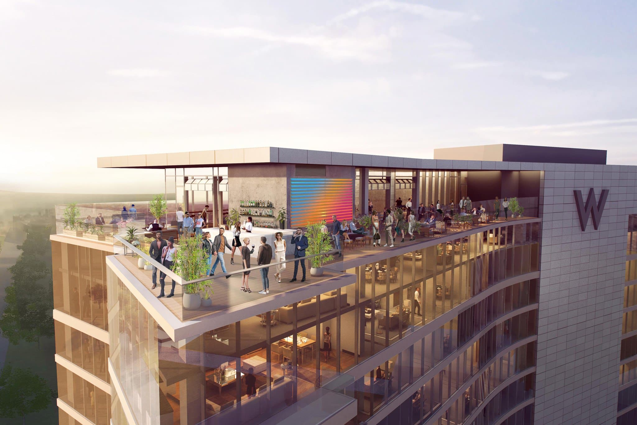 A low-angle shot of the W Nashville exterior featuring the WET Deck pool area with guests lounging in cabanas and the modern glass facade rising behind.