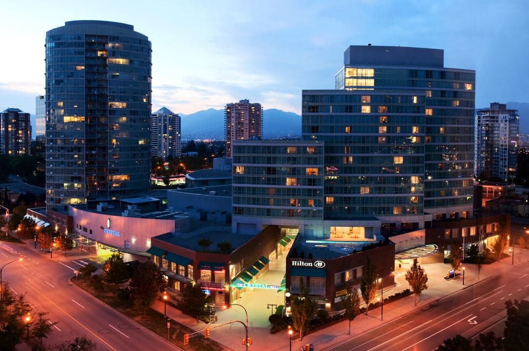Outdoor heated lap pool at Hilton Vancouver Metrotown surrounded by Burnaby skyscrapers.