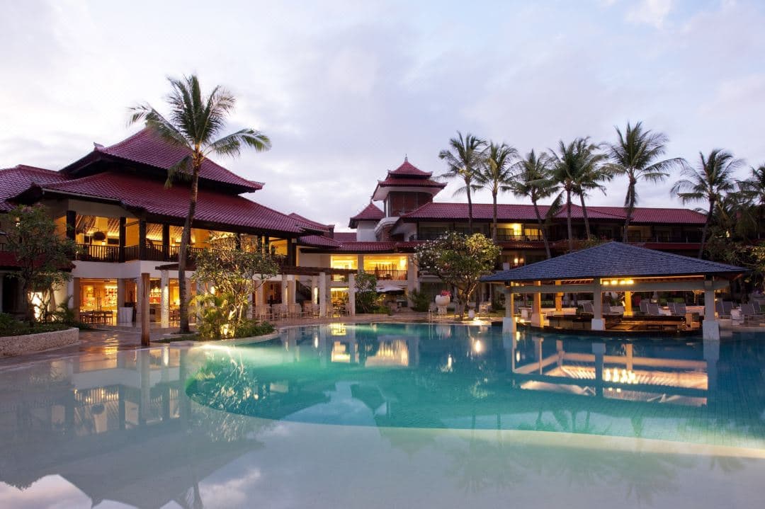 Golden hour at ENVY restaurant with white-draped gazebos facing the South Kuta ocean.