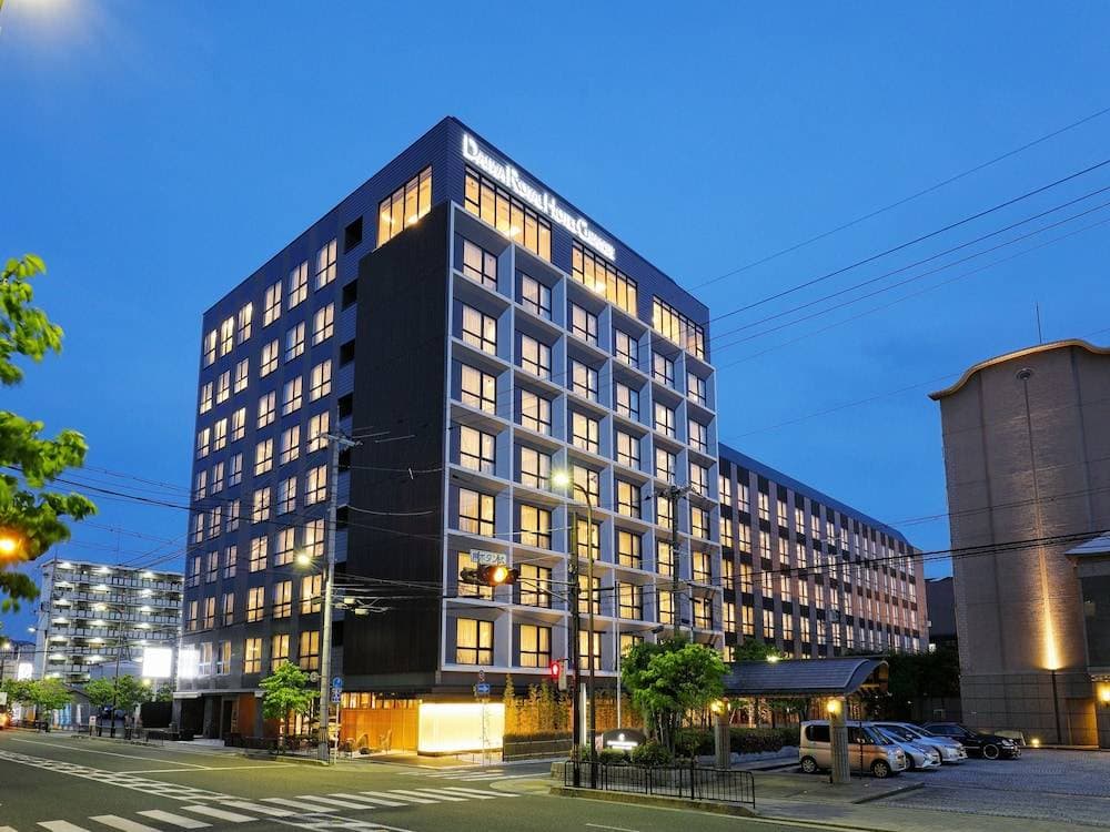 京都站希尔顿逸林酒店大堂,配有大型LED屏幕、暖色调木饰面和金色书法天花板艺术。
