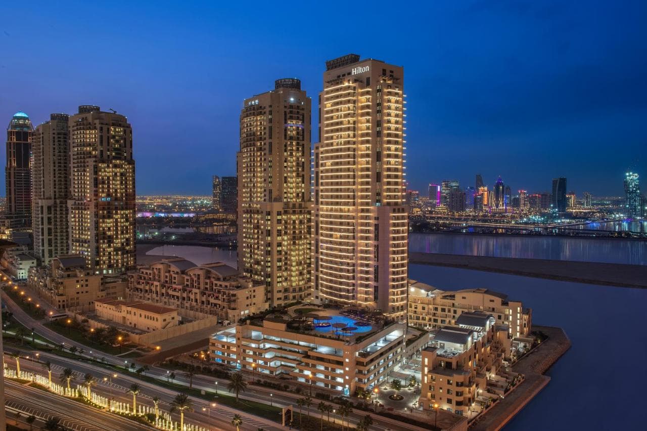 Balcony view from Hilton Doha The Pearl overlooking the marina and Qanat Quartier canals at twilight.