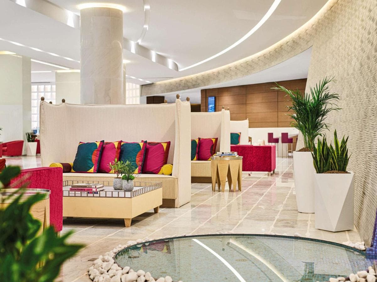 Mathieu Lehanneur's rotating globe sculpture in the lobby of Pullman Doha West Bay with modern art installations in the background.