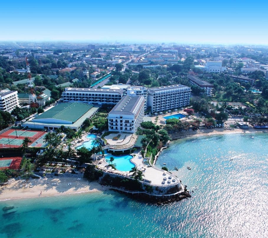 The massive indoor atrium garden of Dusit Thani Pattaya featuring a large waterfall and lush tropical plants.
