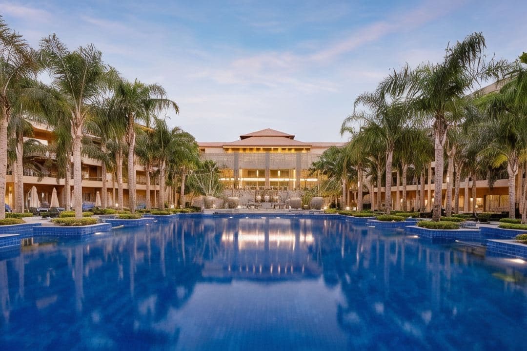A serene, palm-lined swimming pool at Dusit Thani LakeView Cairo, reflecting the warm Egyptian sun with Thai-inspired architecture in the background.