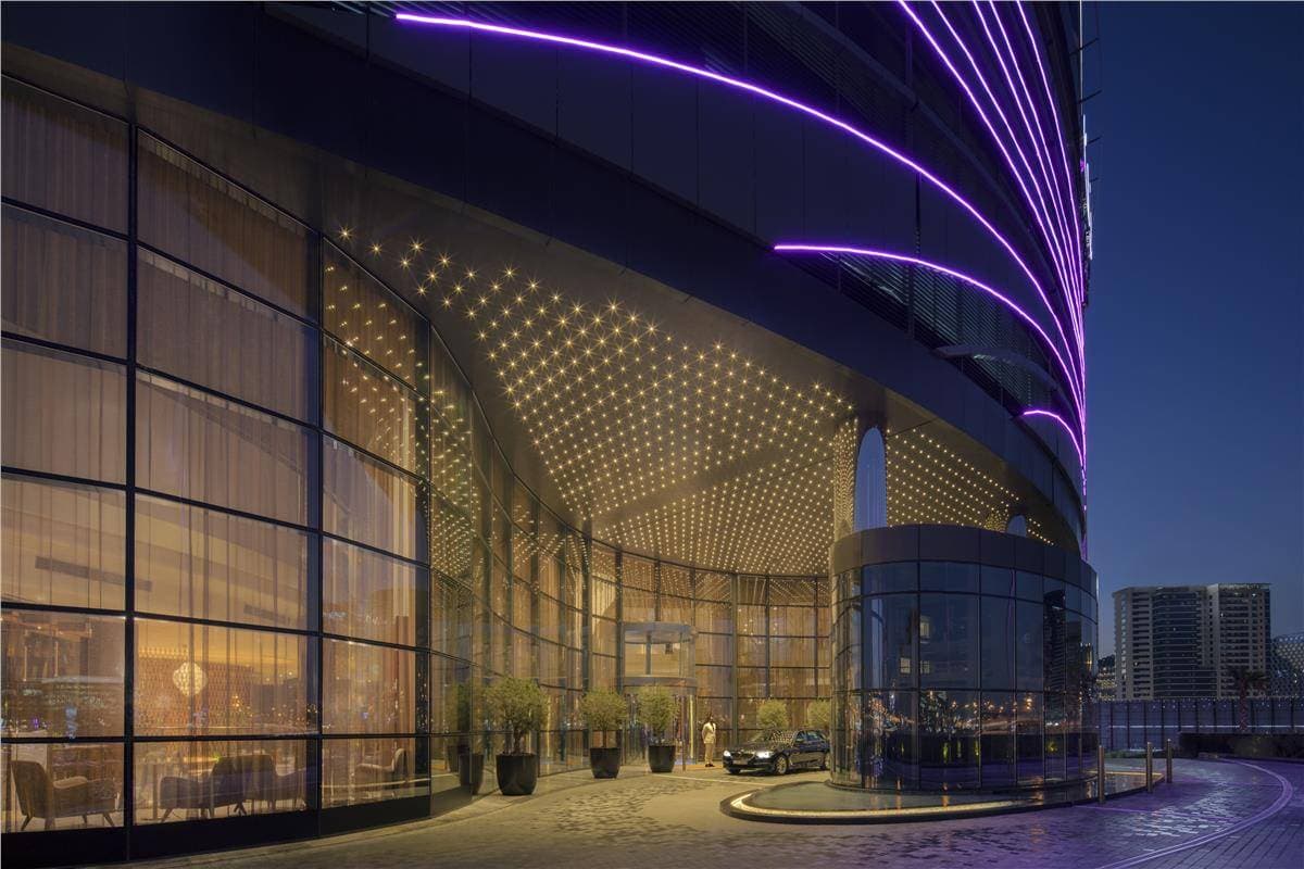 A glamorous, Hollywood-themed hotel lobby featuring floor-to-ceiling digital screens displaying classic movie scenes.