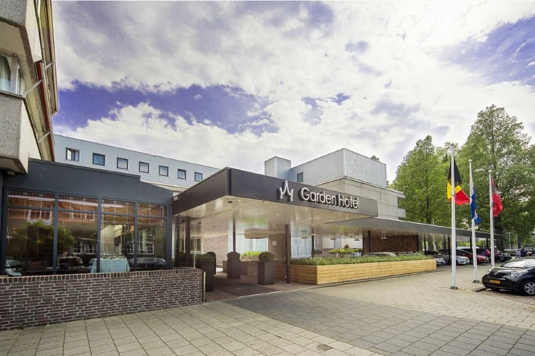 Exterior of Bilderberg Garden Hotel featuring 'The Open Cherry' sculpture and modern brick facade in Amsterdam Oud-Zuid.