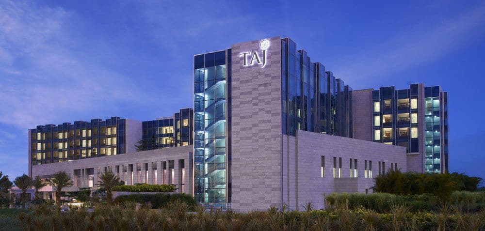The sun-drenched atrium of Taj Bangalore featuring the signature 'Tree of Life' sculpture and water features.