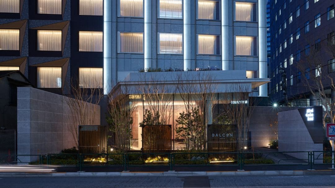 View from the BALCÓN TOKYO terrace at night featuring the illuminated Tokyo Tower and sleek outdoor seating.