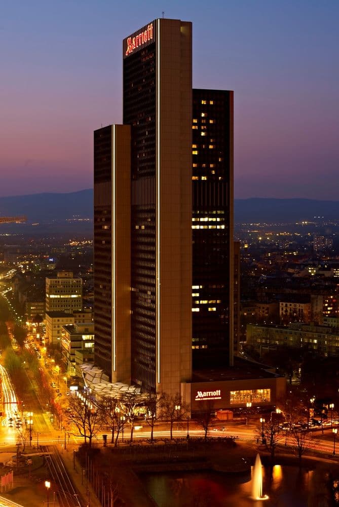 View from a high-floor room at Frankfurt Marriott showing the illuminated 'Mainhattan' skyline and the Messe trade fair tower at night.