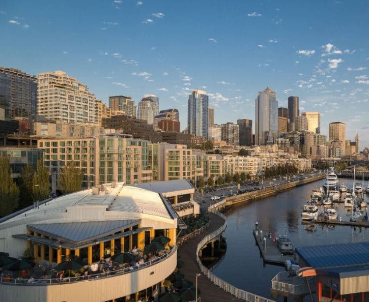 A view from a balcony at Seattle Marriott Waterfront overlooking Elliott Bay and the Great Wheel at sunset.