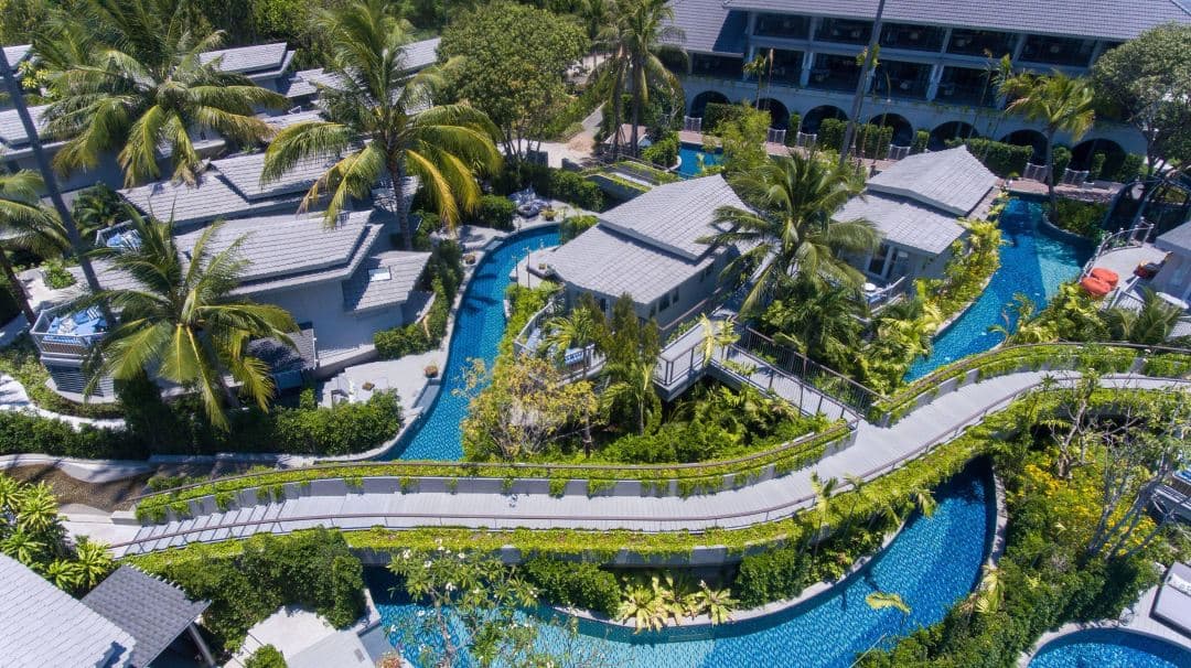 Aerial view of Meliá Koh Samui featuring the 700m Loop Pool winding around the teak Boat Suites and tropical gardens.