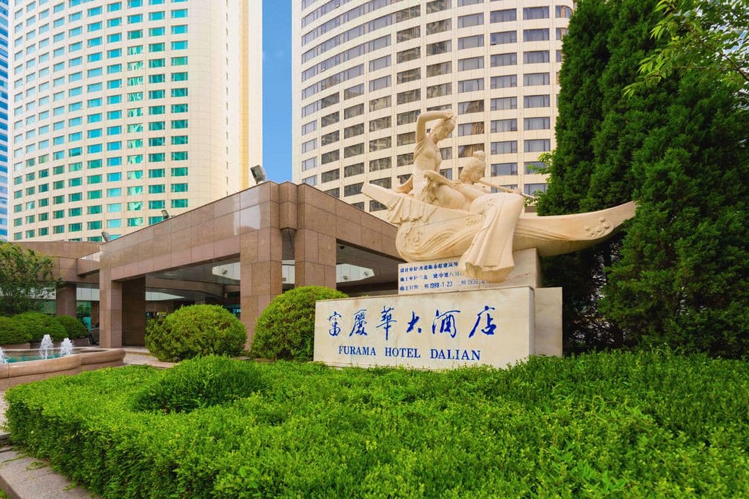 大連世界博覧広場近くにある大連フラマホテルの外観と清潔な客室。