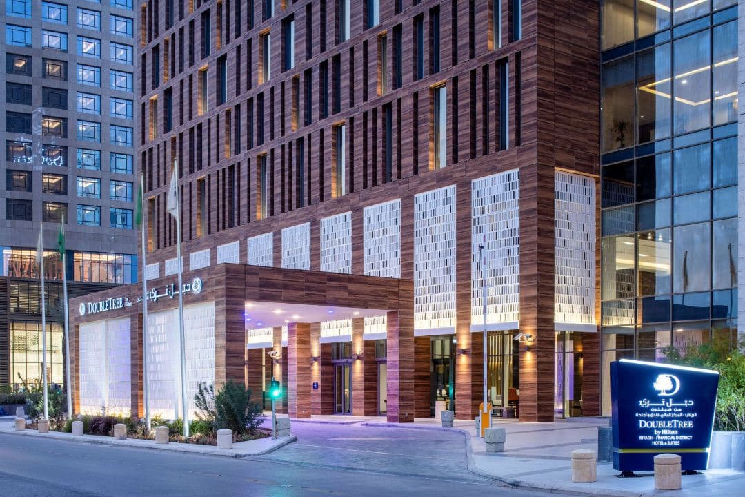 Looking up through the glazed slot atrium of the DoubleTree Riyadh, showing geometric skylights and modern architectural lines.