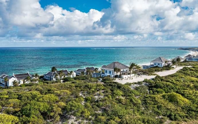 A standalone beachfront bungalow at Ambergris Cay with a private heated plunge pool overlooking the turquoise ocean and white sand.