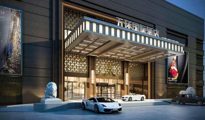 Grand lobby of Changchun Wuhuan International Hotel featuring retro marble pillars and a large crystal chandelier.