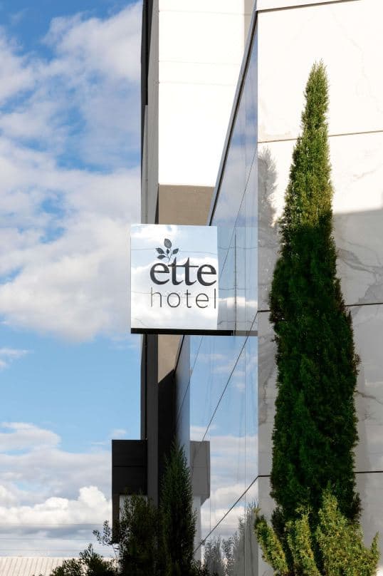 The minimalist lobby of Ette Hotel Orlando featuring a 35-year-old olive tree and Italian marble flooring.