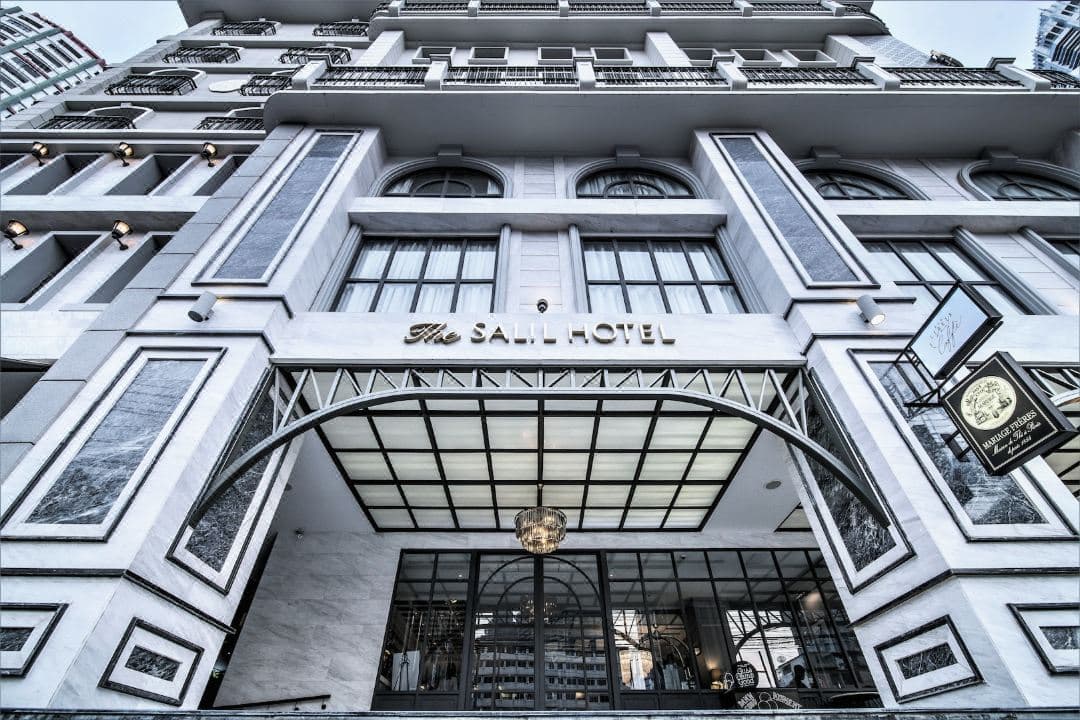 복잡한 새장 샹들리에와 흑백 대리석 바닥이 특징인 The Salil Hotel Sukhumvit 57의 드라마틱한 나선형 계단.